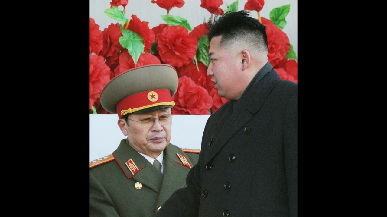 Kim Jong Un walks past his uncle after reviewing a parade of thousands of soldiers commemorating the 70th birthday of the late Kim Jong Il in Pyongyang on February 16, 2012.