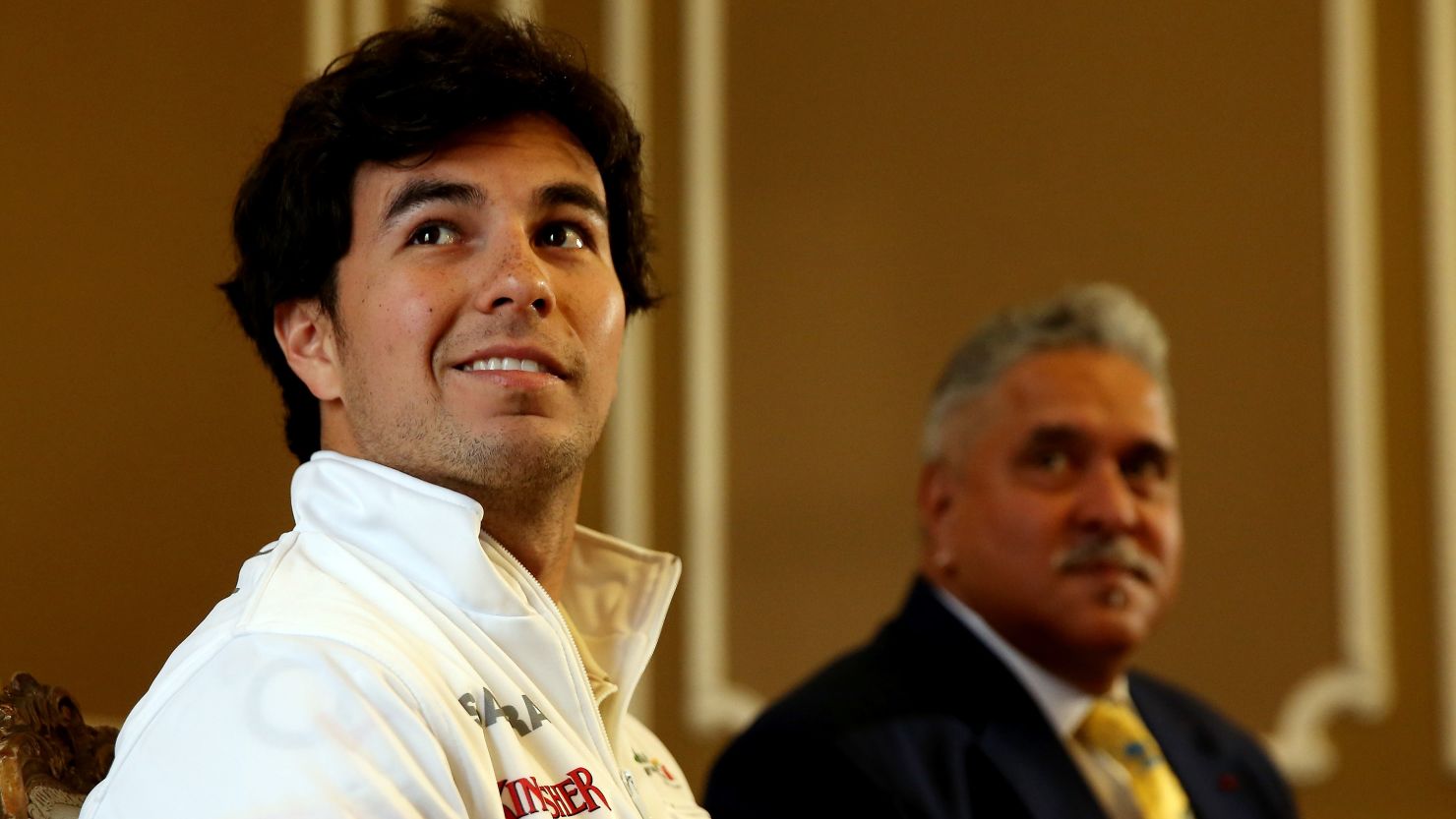 All smiles for Mexican racer Sergio Perez as he signs for Force India under the watchful eye of new boss Vijay Mallya