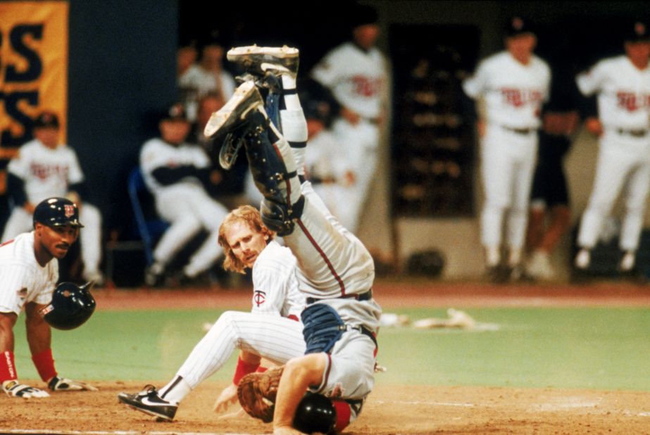 Dan Gladden of the Minnesota Twins looks back after colliding with the Atlanta Braves catcher at home plate during a 1991 World Series game in Minneapolis.
