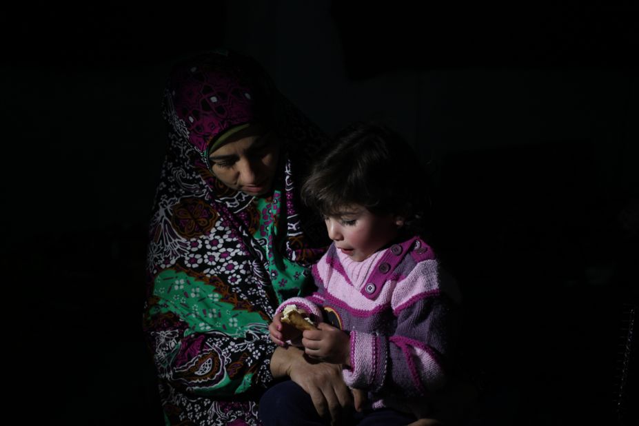 Syrian refugee widow Ikhlas Halawani feeds her daughter breakfast during a snowstorm in Amman, Jordan, on December 12.