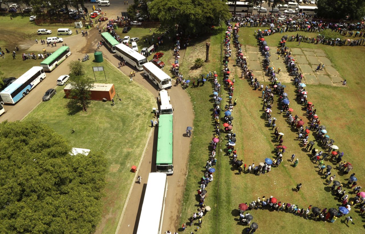 People queue to catch a bus to see the remains of Nelson Mandela at the Union Buildings on December 12.