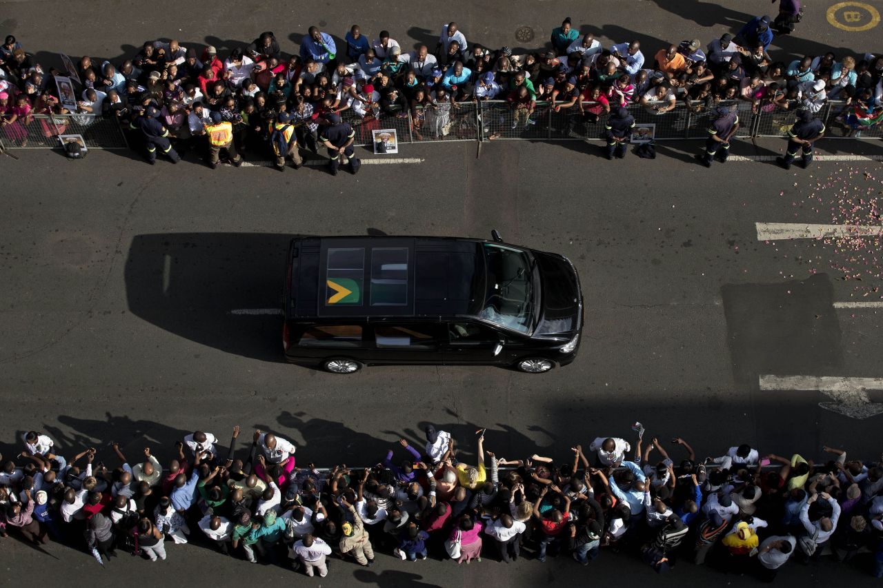 Mandela's funeral procession drives toward the Union Buildings on December 12. Each morning his remains were transported from the mortuary to the government buildings.