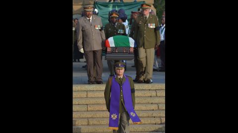 The national flag-draped coffin of the former South African President is carried down steps of the Union Buildings at the end of the third and final day of lying in state on December 13.