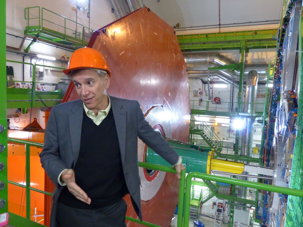 Joe Incandela, the spokesperson for CMS, says that about 4,000 scientists collaborate on the experiment. Behind him is a new red-colored layer to improve the detection of muons, which are fundamental particles