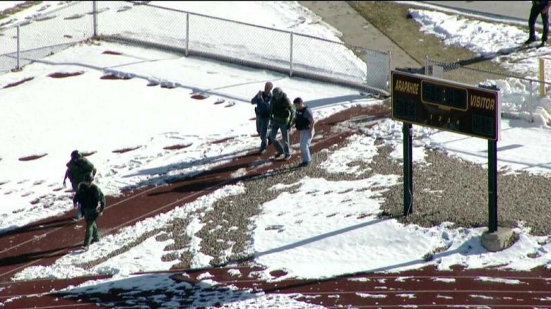 Members of law enforcement are seen outside the school.