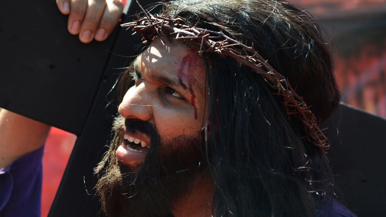 Indian Christian Alan D'Souza portrays Jesus as he carries a cross through a residential area on Good Friday in Mumbai on March 29, 2013. A procession of Indian Christians from all walks of life participated in the march portraying the suffering meted out by Roman soldiers to Jesus on his way to be crucified. 