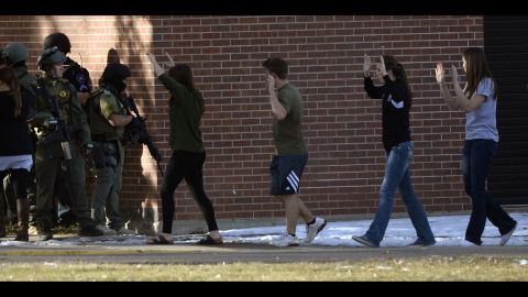 Students are escorted out of Arapahoe High School in Centennial, Colorado, on December 13. 
