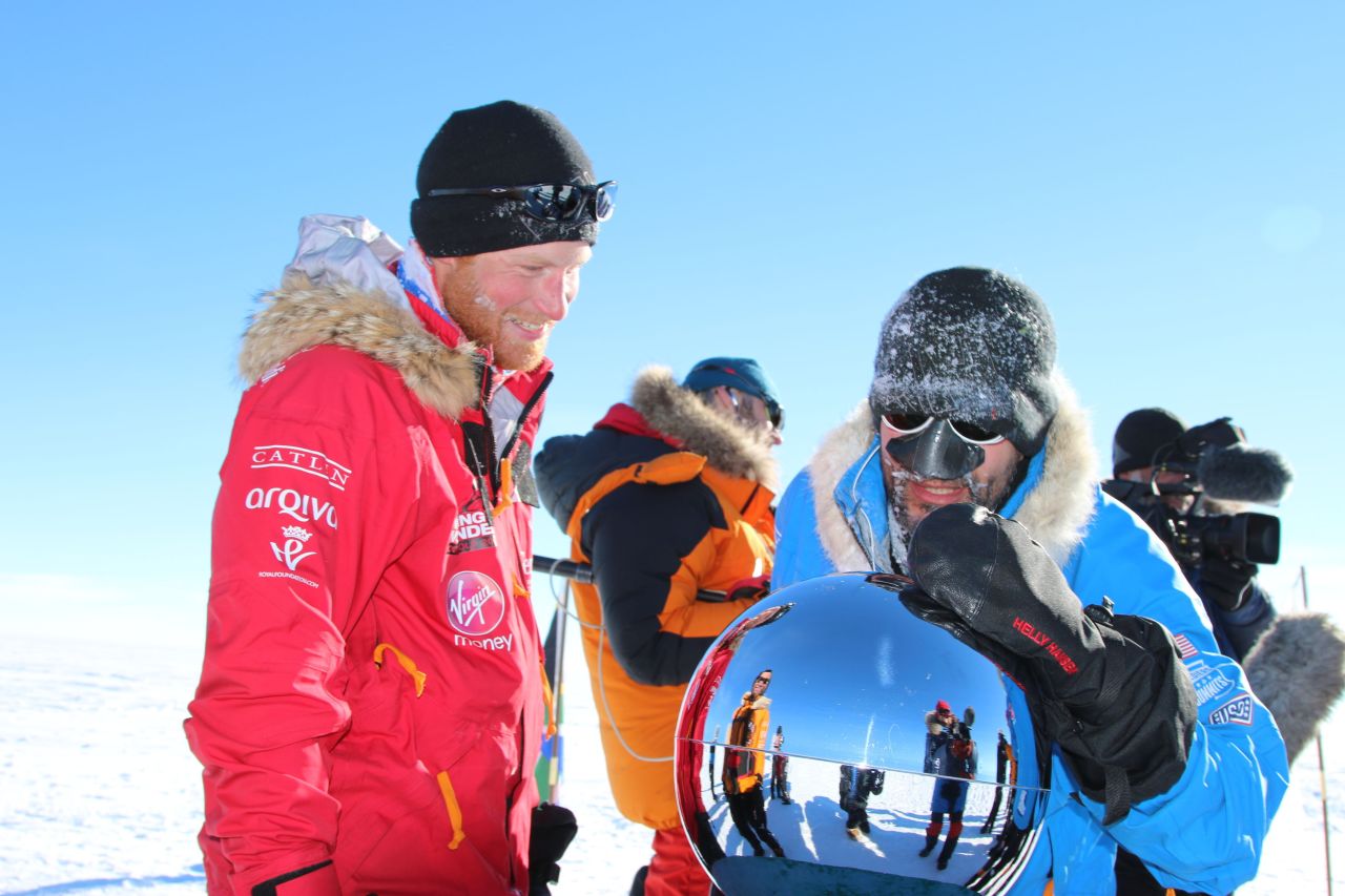 Britain's Prince Harry, left, and Ivan Castro, touch the pole, as they and their fellow adventurers reach the South Pole, as part of their Walking With The Wounded charity trek, Friday, December 13. After more than three weeks pulling sleds across more than 300 kilometers of Antarctica, the group stood at the bottom of the world at midday.