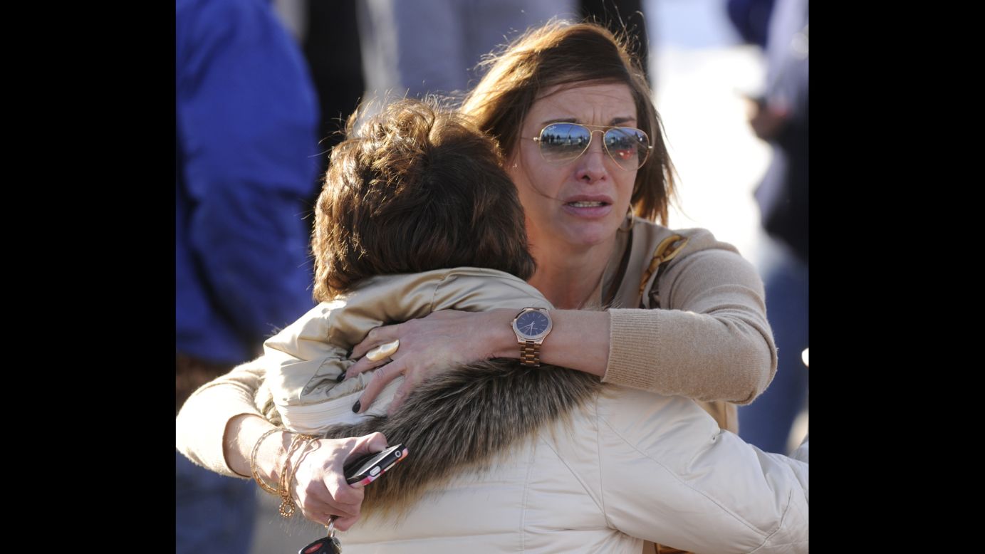 Parents Cathy Thorson, left, and Heather Moran, facing the camera, embrace while they wait for news on their children.