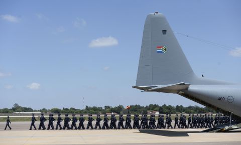 Troops march near the plane that transported Mandela's remains to the village of Qunu for a state funeral on Sunday. 
