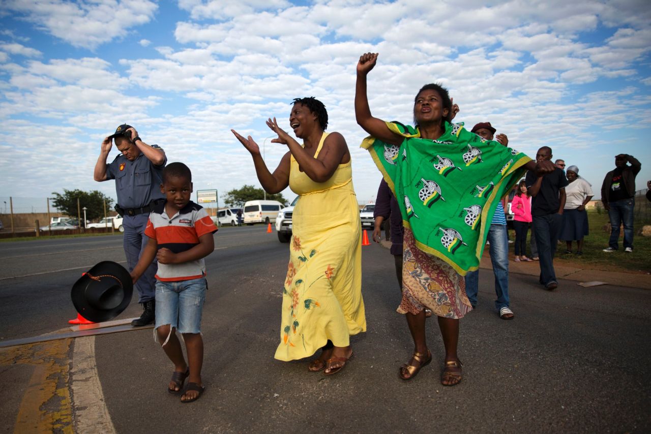 Women sing and dance after the hearse arrived at Waterkloof air base.