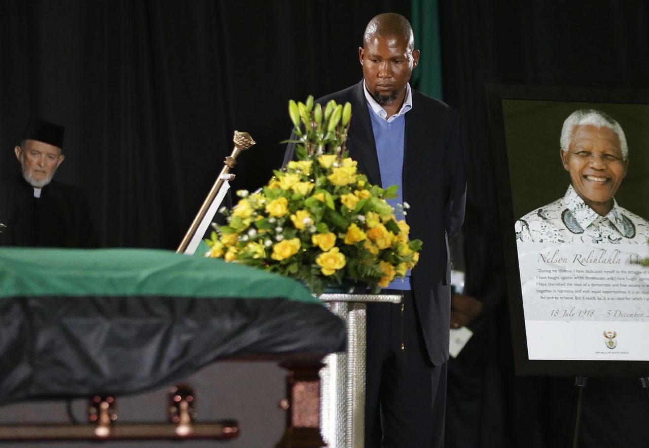 Mandela's grandson Mandla Mandela walks by his grandfather's casket during a farewell ceremony at Waterkloof air base.