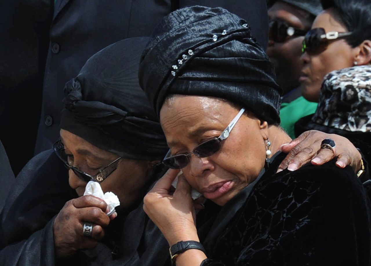 Nelson Mandela's widow Graca Machel, right, and Winnie Madikizela-Mandela, his former wife, wipe their tears as the former president's casket arrives at Mthatha Airport on December 14.