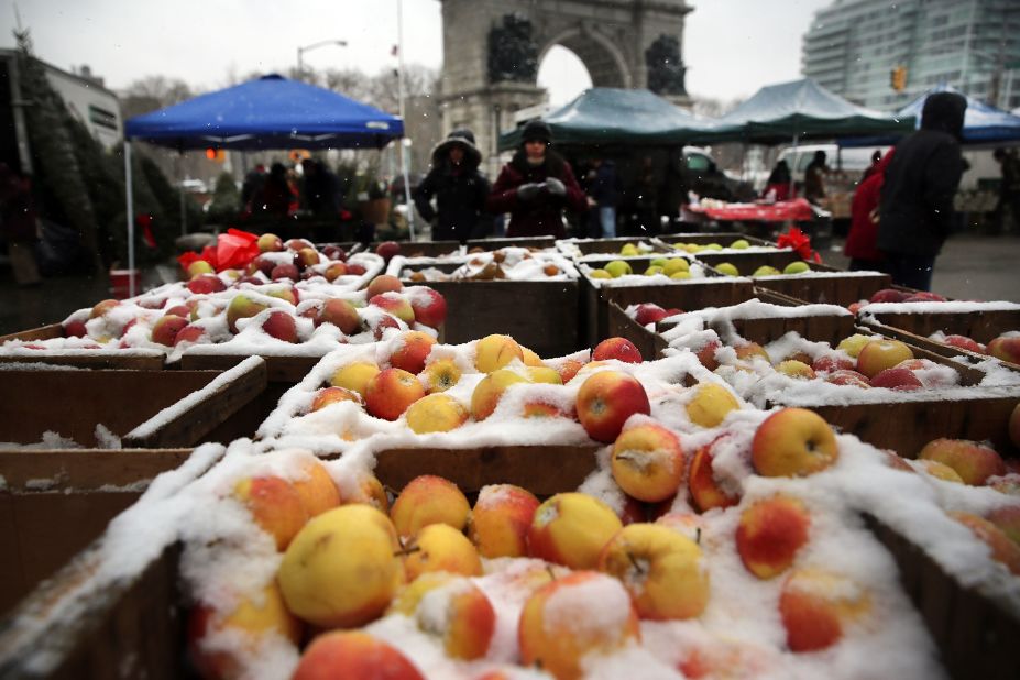 Apples at a Brooklyn street market are covered in snow on Saturday, December 14, in New York.