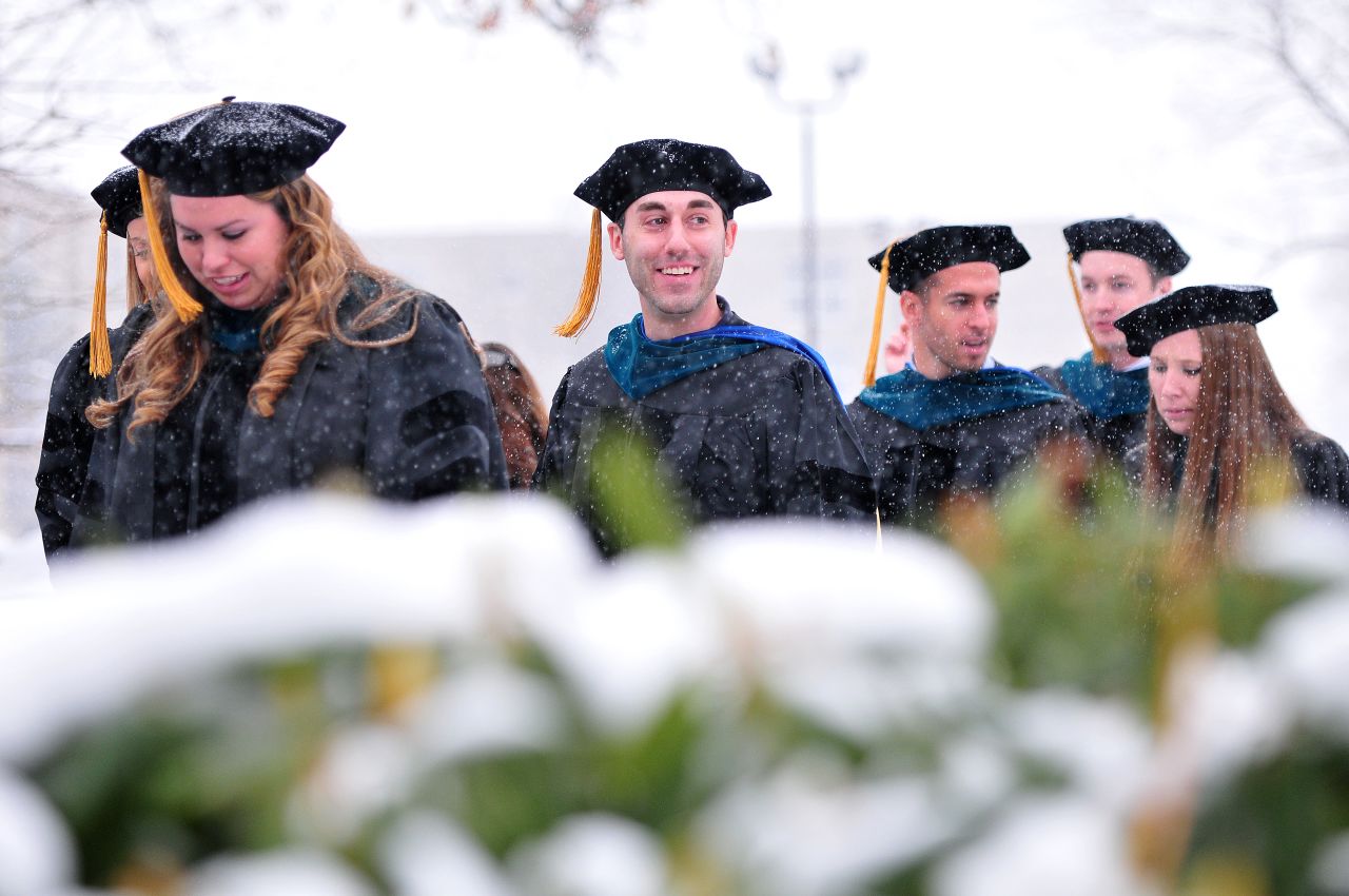 Graduates from Misericordia University make their way through the snowy campus for their commencement convocation on December 14 in Dallas, Pennsylvania.