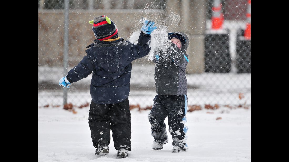 Landon Jackloski, left, and Patrick Craig engage in a snow fight on December 14 as snow falls during the tree-lighting ceremony at Forty Fort Park in Forty Fort, Pennsylvania. 