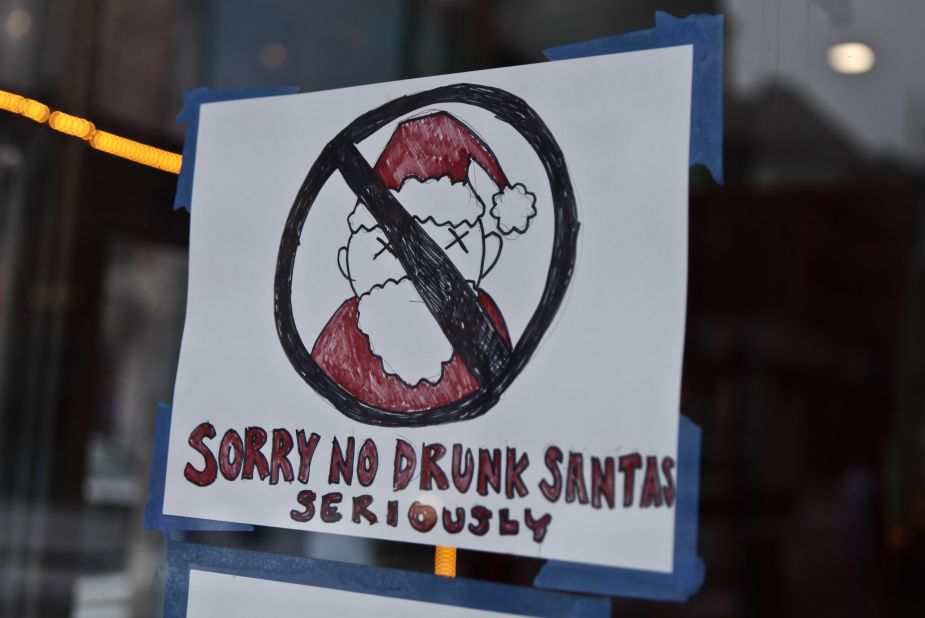 A poster banning SantaCon participants is displayed outside a restaurant in the Lower East Side. Some community groups have established a "Santa-Free" zone that urges bars not to serve alcoholic beverages to people participating in order to dissuade incidents of public vomiting and urination in the streets. 