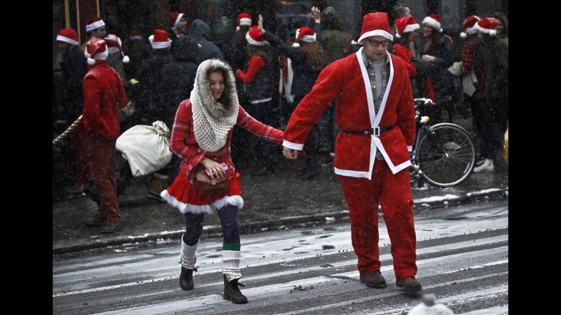A couple dressed as Santa and Mrs. Claus cross the street in Manhattan. 