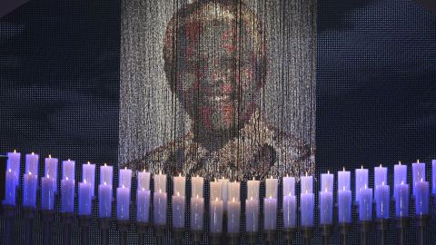 Candles are lit under a portrait of Mandela before the funeral ceremony.