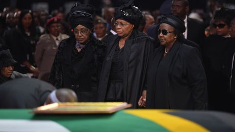 Mandela's ex-wife Winnie Madikizela Mandela, left, and his widow Graca Machel, center, stand by Mandela's casket during his funeral ceremony in Qunu on December 15.