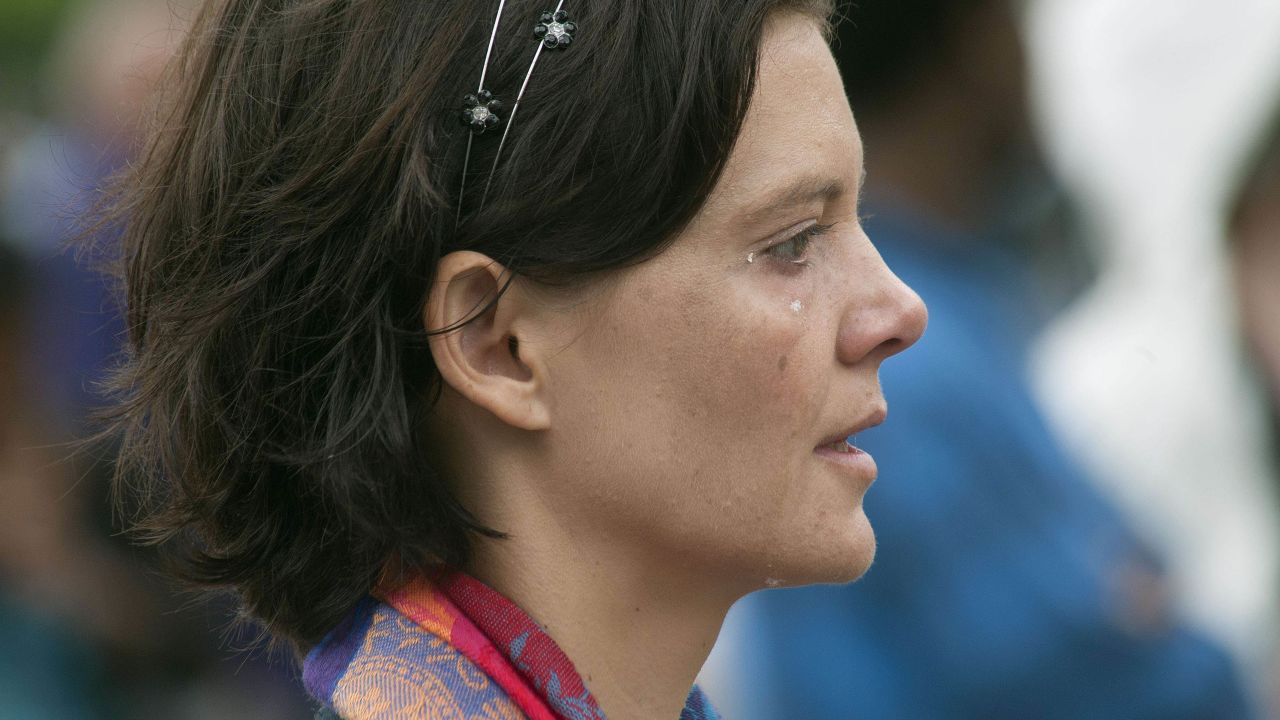 A woman cries as she watches the funeral ceremony on big screens in front of the Cape Town City Hall.