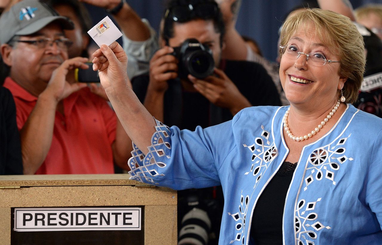 La candidata de Nueva Mayoría, la expresidenta Michelle Bachelet, sonríe ante las cámaras al votar en Santiago.