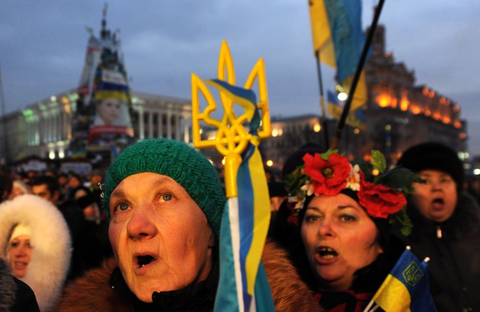 People sing, shout slogans and wave Ukrainian and EU flags during a mass rally in Independence Square on December 15.