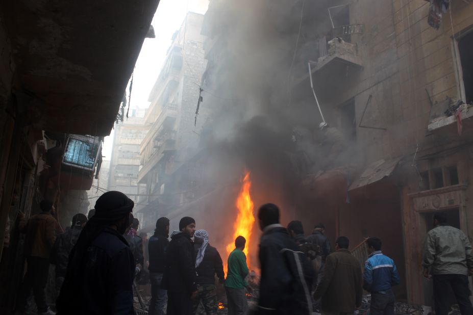 Syrians look at the aftermath of an airstrike on a rebel area of Aleppo on December 15.