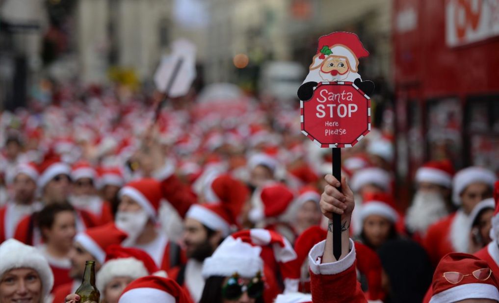 Hundreds of people dressed in Santa Claus costumes march through central London during the annual SantaCon celebration on December 14.