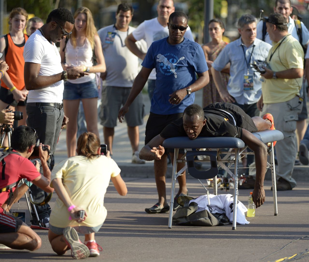 Bolt poses for photos while having a massage prior to the race, on the famous 9th of July Avenue in Buenos Aires, and told reporters he was aiming to defend his three Olympic titles in Rio 2016.