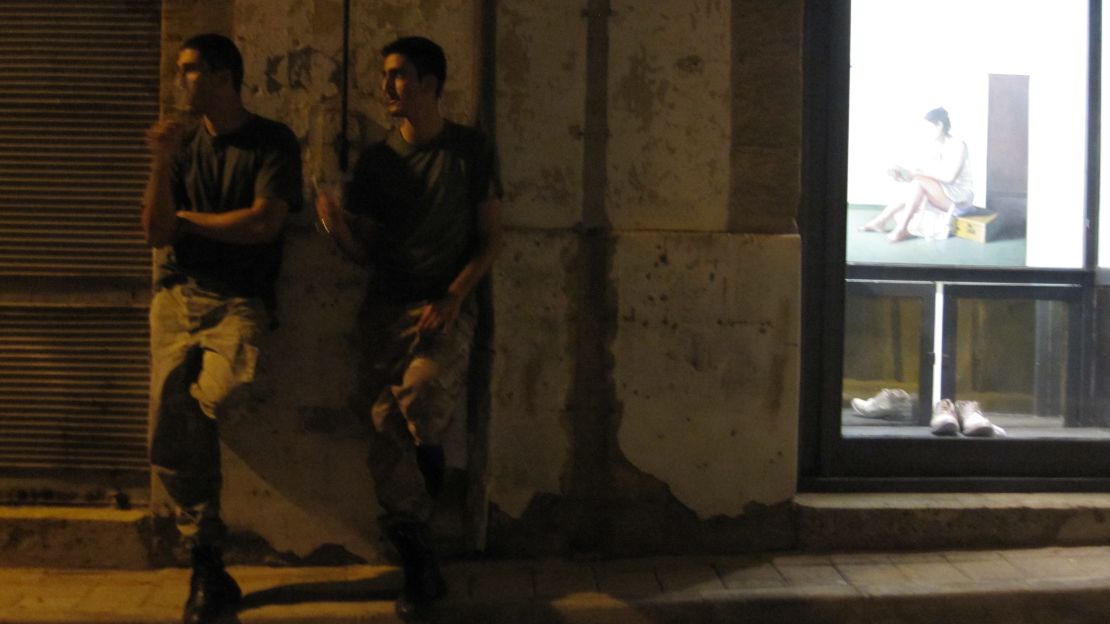 Two soldiers share a cigarette outside the The Office art gallery, Nicosia