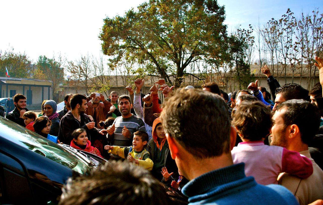 Evander Holyfield and Yank Barry were surrounded by hundreds of refugees angry at conditions in the Harmanli camp, near Bulgaria's border with Turkey.