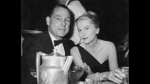 Fontaine and Collier Young sit together at a restaurant table at the Biltmore Hotel in New York City in 1956.