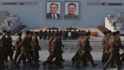 North Koreans soldiers march on Kim Il Sung Square in Pyongyang as others pay their respects beneath portraits of the late leaders Kim Jong Il, right, and Kim Il Sung on Tuesday, Dec. 17, 2013. North Koreans observed the second anniversary of the death of Kim Jong Il. (AP Photo/David Guttenfelder)