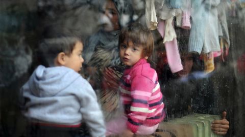 A child looks through a window while food and aid is distributed at a refugee center in Sofia, Bulgaria, on Tuesday, December 17.