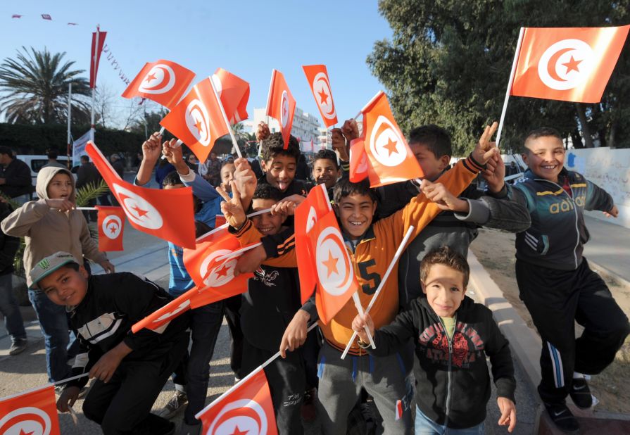 Children wave the national flag in Mohamed Bouazizi square.