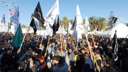 Members of Tunisian Islamist party Hizb-Ut-Tahrir hold islamist flags as they gather to mark the third anniversary of the uprising that toppled deposed president Zine El Abidine Ben Ali in Sidi Bouzid's Mohamed Bouazizi square on December 17, 2013.