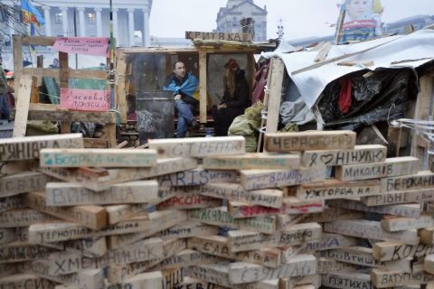 Protesters sit behind wood bricks in Independence Square on December 17. Written on the bricks are names of Ukrainian settlements whose inhabitants are taking part in the demonstrations.