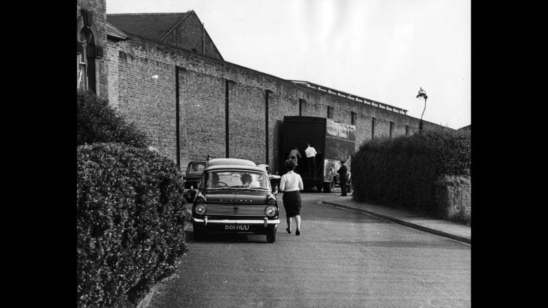 People walk around Wandsworth Prison the day after Biggs escaped with three other prisoners in 1965. Biggs made his escape by jumping through a hole in the roof of the furniture van shown here, onto mattresses, and then out of the back of the van into a waiting car.