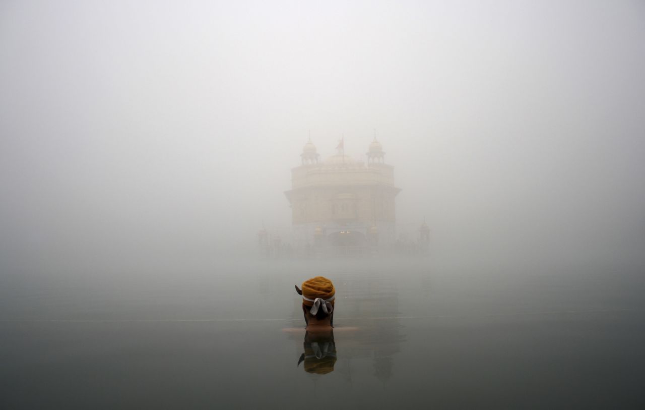 DECEMBER 18 - AMRITSAR, INDIA: A Sikh devotee takes a holy bath in a sacred pond at the Golden Temple, the holiest Sikh shrine, amid thick fog. <a href="http://timesofindia.indiatimes.com/india/Fog-disrupts-train-schedules-in-north-India/articleshow/27576738.cms" target="_blank" target="_blank">The extreme weather threw rail traffic out of gear in north India for the third consecutive day, </a>according to reports.