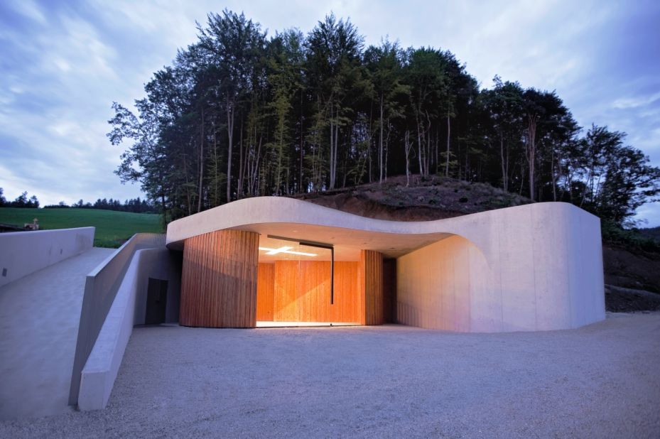 Located next to a graveyard outside of Ljubljana, this curvaceous chapel by Ofis Arhitekti mimics the slopes of the surrounding landscape.