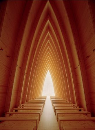 Step inside and you'll find the arched pine wood ribs leading to a back-lit alter. Designed by Sanaksenaho Architects.
