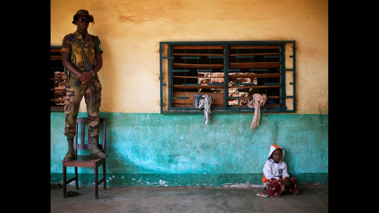 An African Union peacekeeper stands on a chair December 18 as a small child sits on the floor of an Islamic center where refugees have sought protection in Bangui.