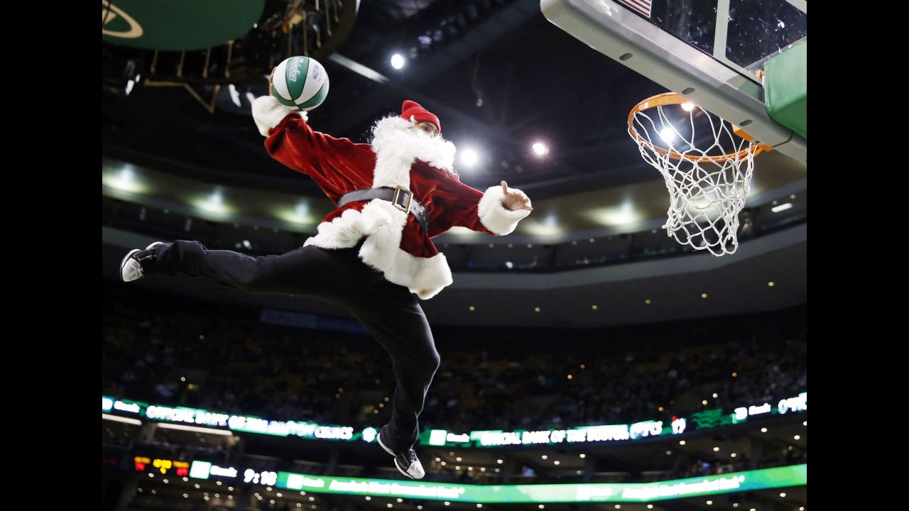A performer in a Santa Claus costume dunks the ball during a timeout in the fourth quarter of an NBA basketball game between the Boston Celtics and the Minnesota Timberwolves in Boston on Monday, December 16.