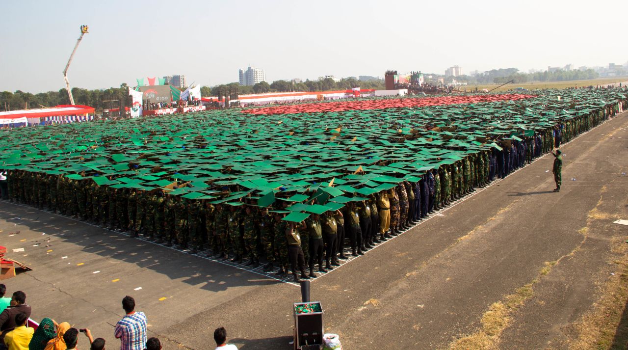 Students and army officials hold green and red placards to create the Bangladeshi flag, which was adopted in 1972 after Bangladesh gained independence.