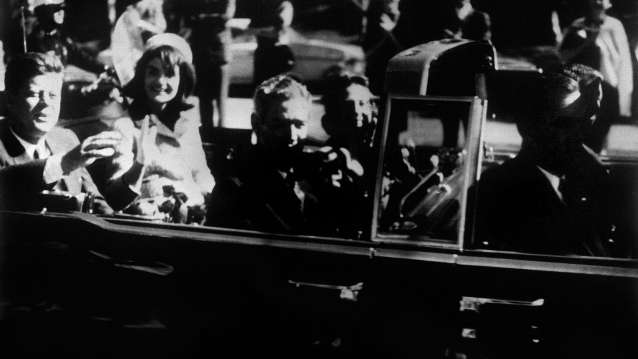 U.S. President John F. Kennedy and his wife, Jackie, ride in an open-top limousine just minutes before Kennedy was assassinated at Dealey Plaza in Dallas on November 22, 1963.