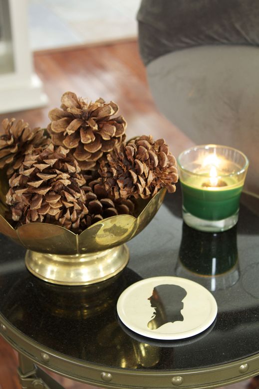 Even a small brass bowl full of pinecones helps reinforce Jones' woodland decor.