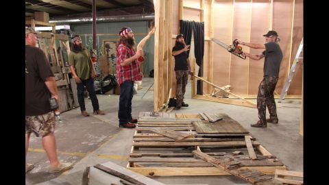 The Duck Commander crew works on transforming their warehouse into a "scarehouse" during a Halloween episode. Holding the chainsaw is Si Robertson, who founded the company along with his brother Phil, not pictured. 