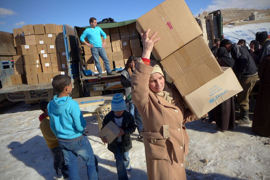 Syrian refugees unload relief supplies at the Shuhada Camp.