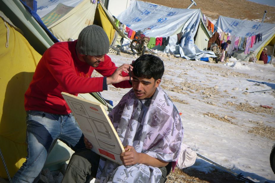 A Syrian refugee gets his hair cut at the  Shuhada Camp.